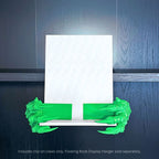 Green 3D printed Dragon Claws Curio Clip-Ons attached to a white Curio Candy Floating Book Display Hanger against a dark wood background with blue top backlighting.