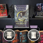 Curio Clip-On Posable Gothic Demon Bat Wings attached to a Curio Candy Floating Book Display Hanger, showing open and closed posable positions with Sarah J. Maas's House of Sky and Breath on a dark romance bookshelf.