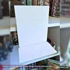 Perspective view of a white 3D printed 80mm Deep Lip Extender attached to the base of an empty white Curio Candy Floating Book Display Hanger on a bookshelf.
