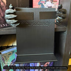 Close-up angle of a pair of black 3D printed Werewolf Hands with detailed fur texture and sharp claws attached to a black display hanger bracket resting on a surface.