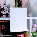 Curio Candy official branded white floating book display hanger showing embossed logo backplate on white bookshelf.